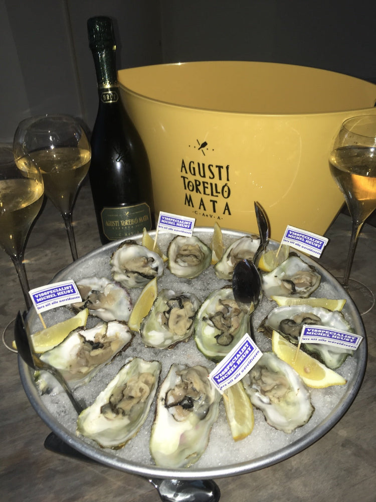 Cava Kripta Brut Reserva fles rechtop met goudkleurige capsule en duidelijk etiket met een schotel oesters en 3 cava glazen 